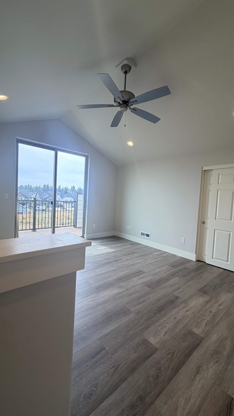 A room with a ceiling fan and a window overlooking a snowy landscape.