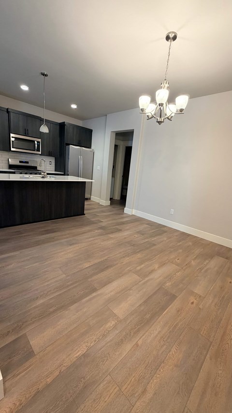 A kitchen with wooden floors and a chandelier.