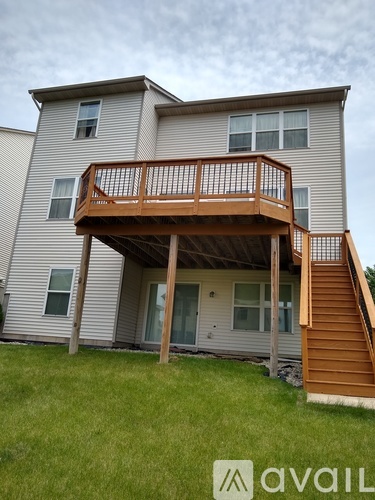 A two-story house with a deck and stairs.