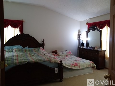 A bedroom with two beds and a dresser with a mirror.