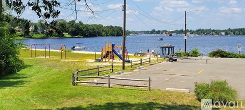 A playground with a slide is located next to a body of water.