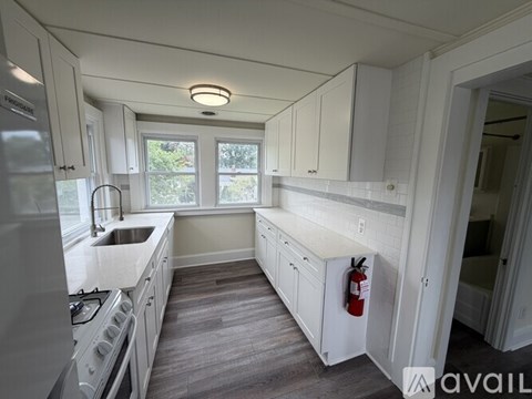 A kitchen with white cabinets and a stove top oven.