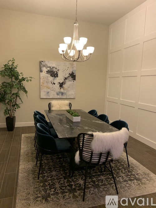 A dining room with a large table and chairs.