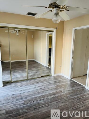 A room with a ceiling fan and a wall with a sliding door.