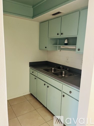 A kitchen with light blue cabinets and a stainless steel sink.