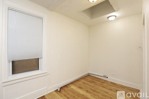 A room with a window and wooden flooring.