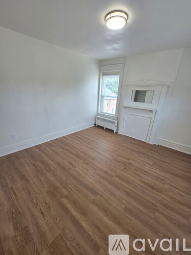 A room with wooden flooring and a window.