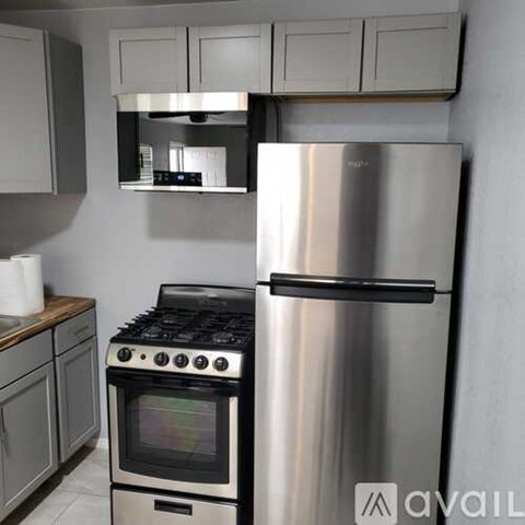 A kitchen with a stainless steel refrigerator and a stove top oven.