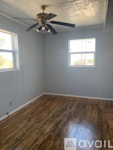 A room with wooden floors and a ceiling fan.