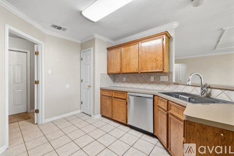 A kitchen with wooden cabinets and a dishwasher.