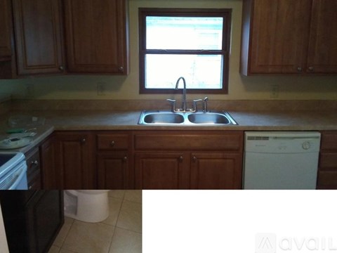 A kitchen with wooden cabinets and a white dishwasher.