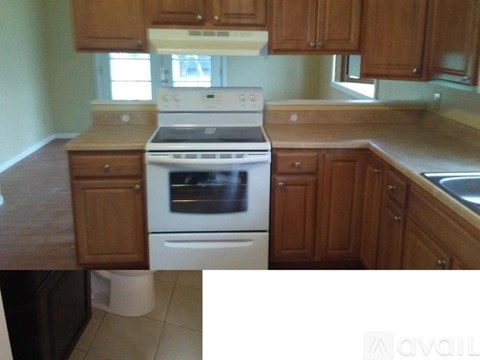 A kitchen with a white oven and wooden cabinets.