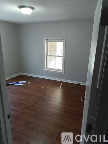 A room with a window and wooden flooring.