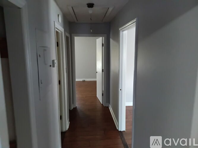 A long hallway with doors on both sides and a wooden floor.