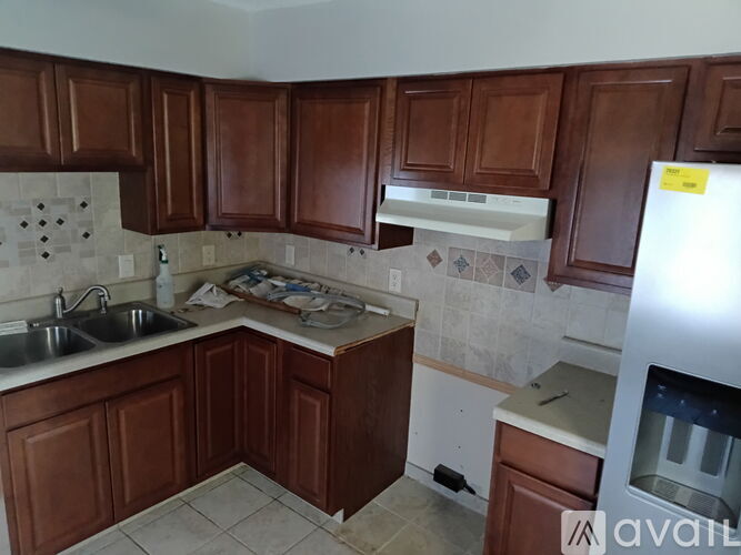 A kitchen with brown cabinets and a white fridge.