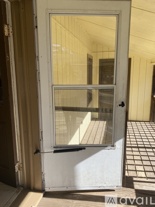A white door with a glass window is open.