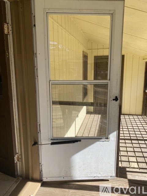 A white door with a glass window is open.