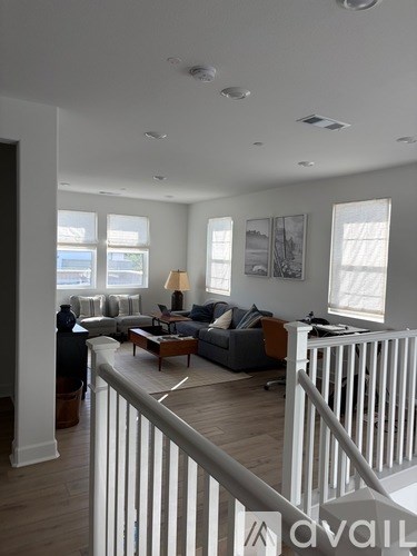 A living room with a couch, a coffee table, and a staircase.