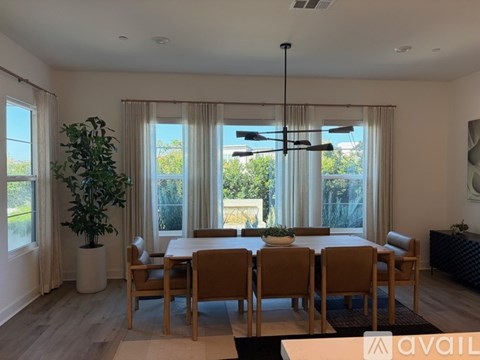 A dining room with a large table and chairs.