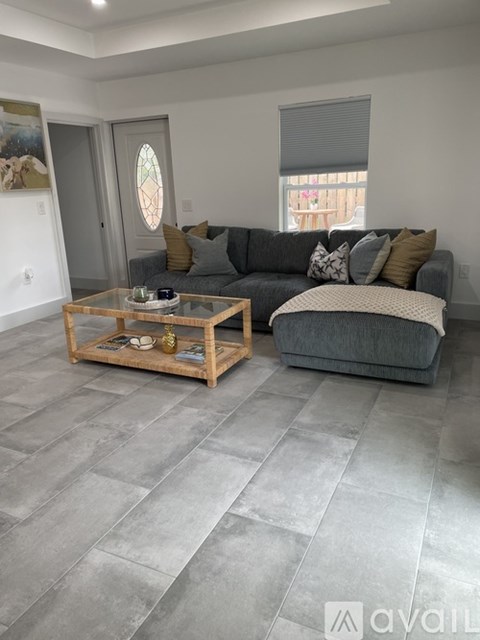 A living room with a grey couch and a wooden coffee table.