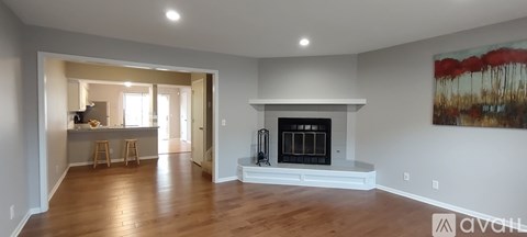 A living room with a fireplace and a painting on the wall.