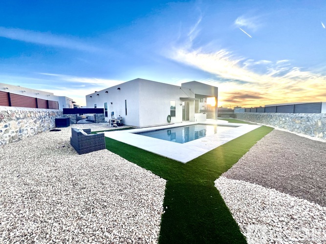 A modern house with a pool in the backyard.