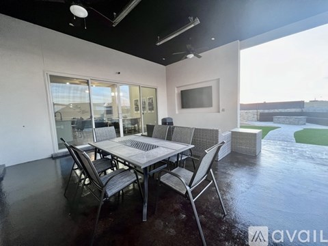 A modern dining room with a glass table and chairs.