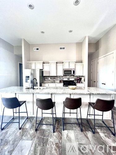 A kitchen with a marble countertop and a bar stool.