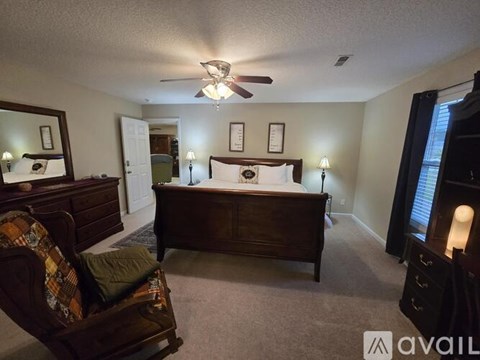 A bedroom with a bed, dresser, and chair.