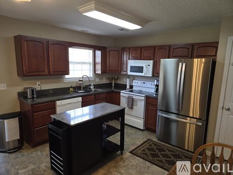 A kitchen with brown cabinets and a black island.