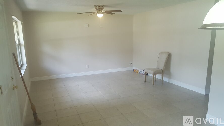 A room with a ceiling fan and a chair.