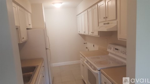 A kitchen with white appliances and cabinets.