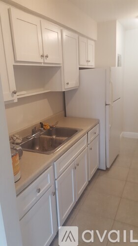 A kitchen with white cabinets and a sink.
