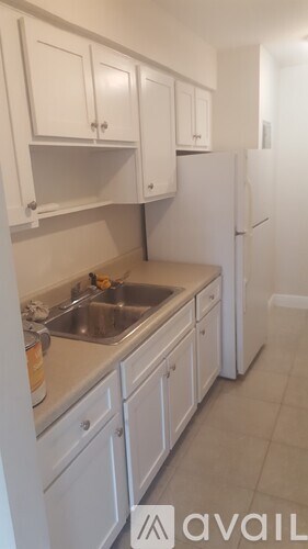 A kitchen with white cabinets and a sink.