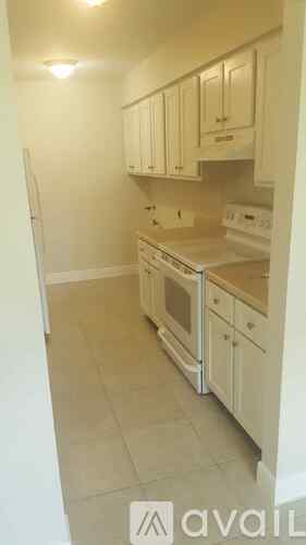A kitchen with white cabinets and appliances.