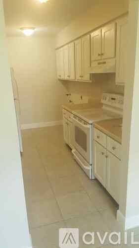 A kitchen with white cabinets and appliances.