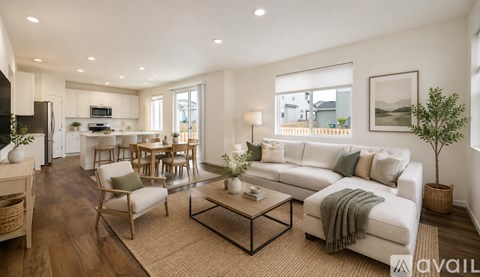 A modern living room with a white sofa, wooden floors, and a large window.