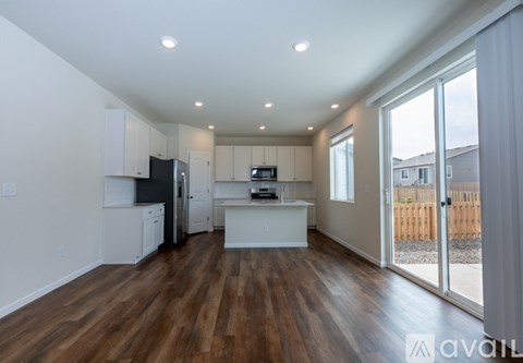A kitchen with white cabinets and a wooden floor.