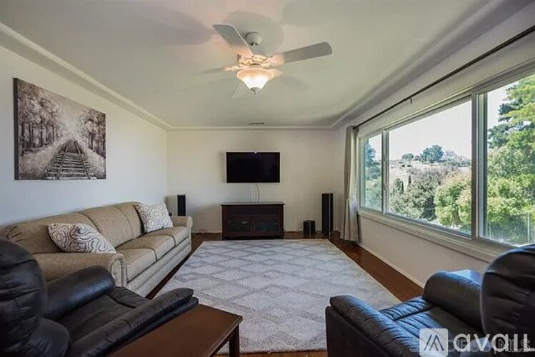 A living room with a couch, a chair, a coffee table, a television, and a fireplace.