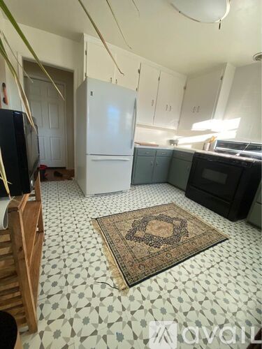 A kitchen with a white fridge and black oven.