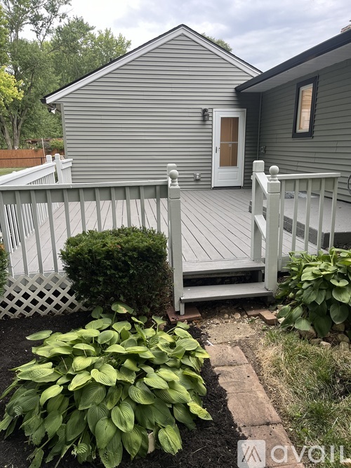 A small house with a white picket fence and a white door.