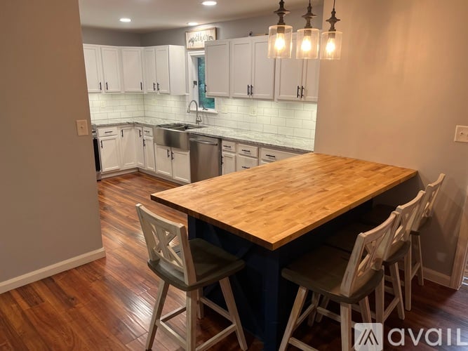 A kitchen with a wooden table and chairs in the foreground.