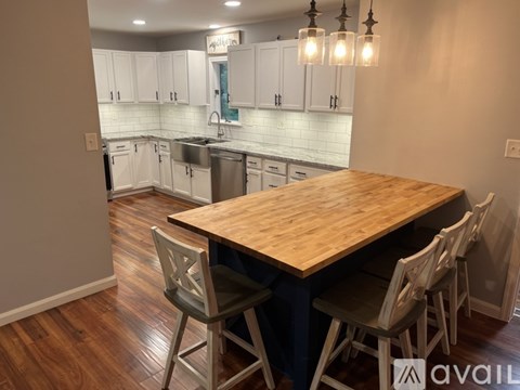 A kitchen with a wooden table and chairs in the foreground.