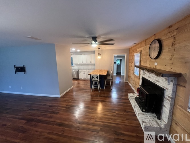 A living room with wood floors and a fireplace.