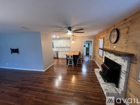 A living room with wood floors and a fireplace.