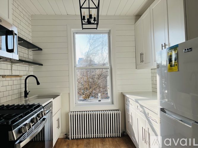 A kitchen with white cabinets and a black stove top oven.