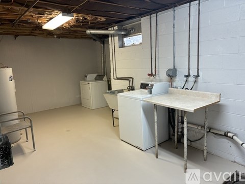 A room with a white table and a white refrigerator.