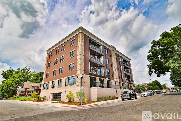 A large apartment building with a parking lot in front.