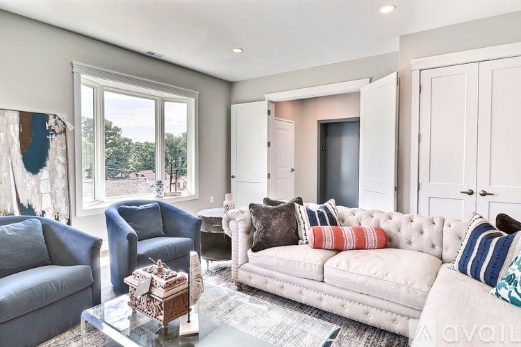 A living room with a white couch and a glass coffee table.