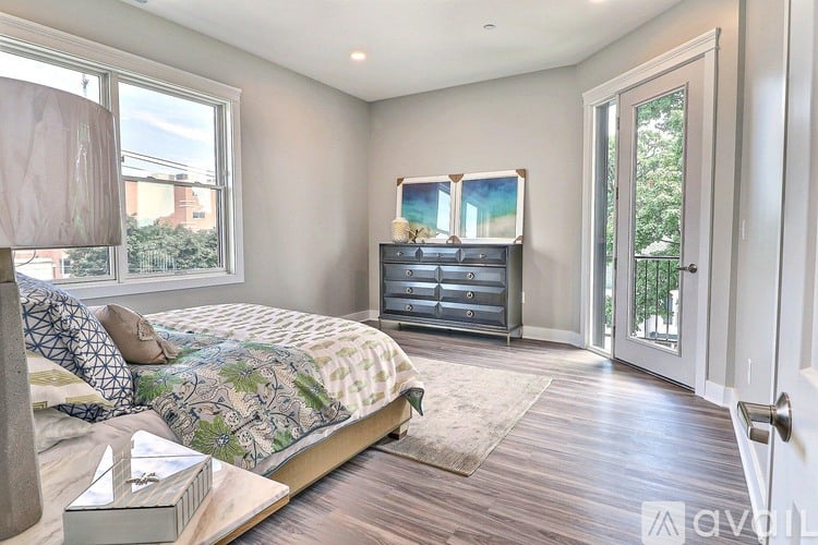 A bedroom with a large bed and a dresser with a mirror above it.